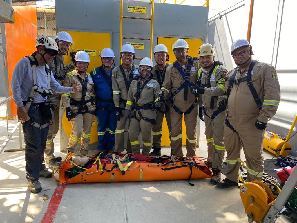 Grupo participa de uma capacitação prática de resgate junto a uma estrutura de treinamento e equipamentos de proteção