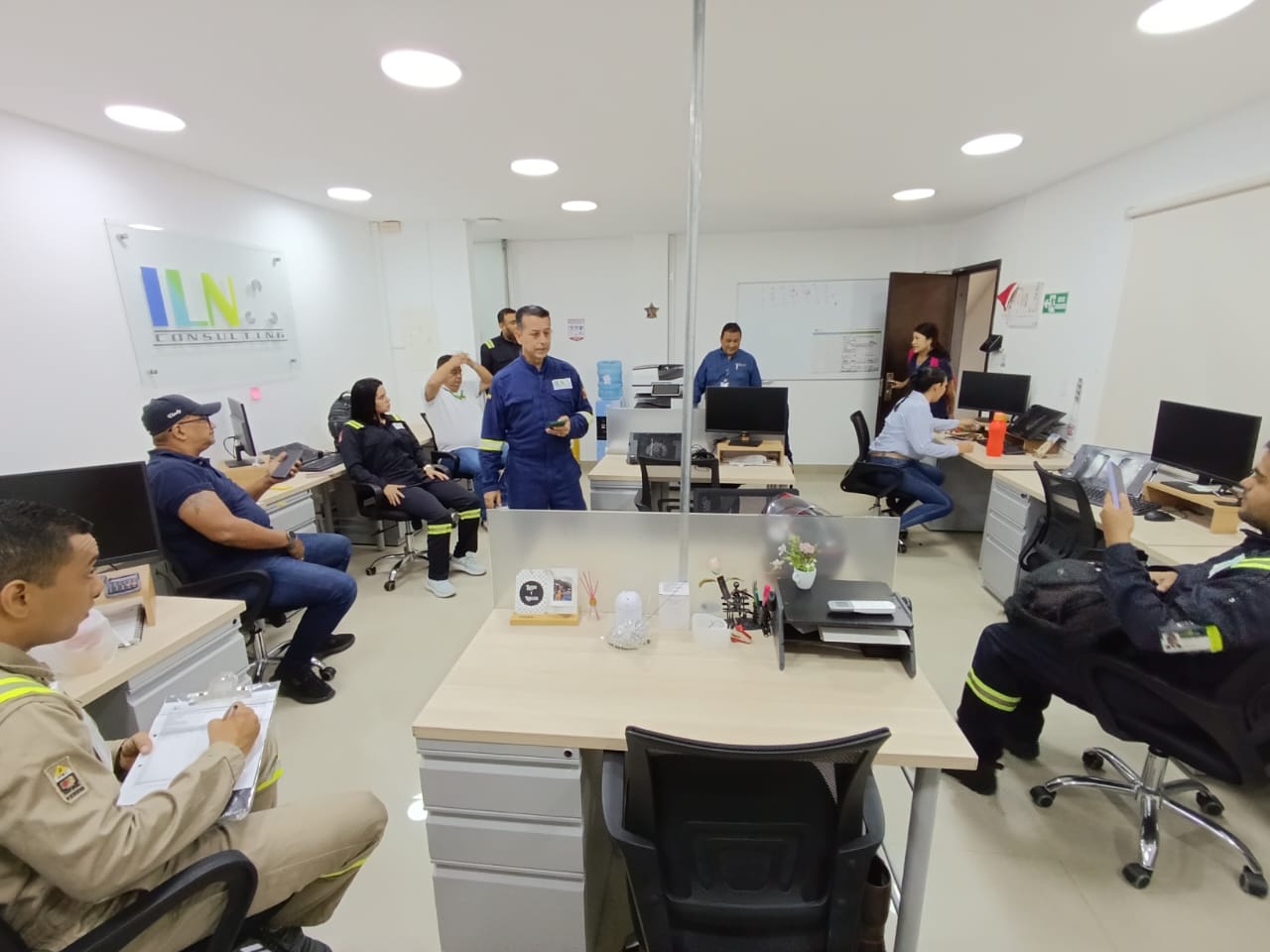 Equipo de ILN reunido en una oficina alrededor de mesas de trabajo